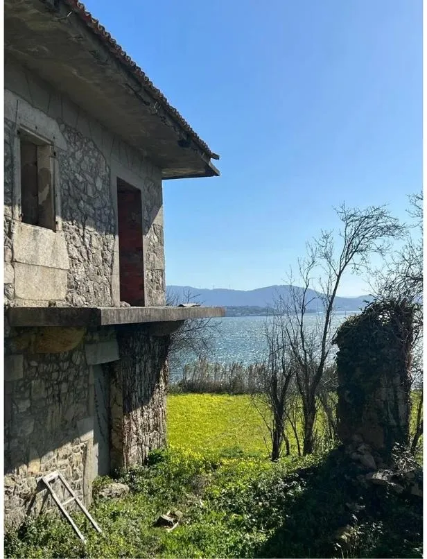 La casona de piedra de Boiro antes de la rehabilitación, con la ría de Arousa al fondo