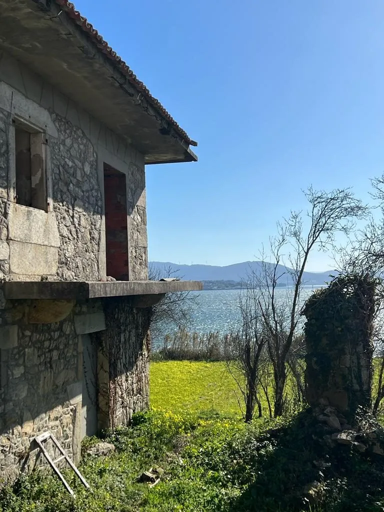 La casona de piedra antes de la rehabilitación, con la ría de Arousa al fondo