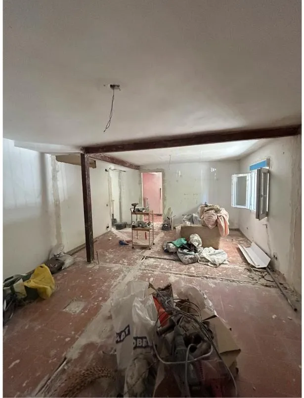 La vivienda antes de empezar: tabiques abiertos, viga de hierro vista y el suelo de barro por levantar