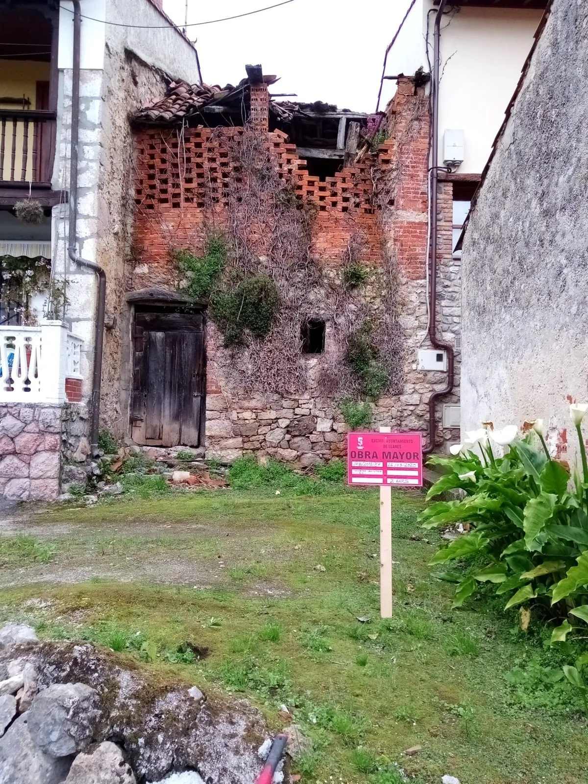 La fachada antes de empezar, con el cartel de obra mayor del Ayuntamiento de Llanes