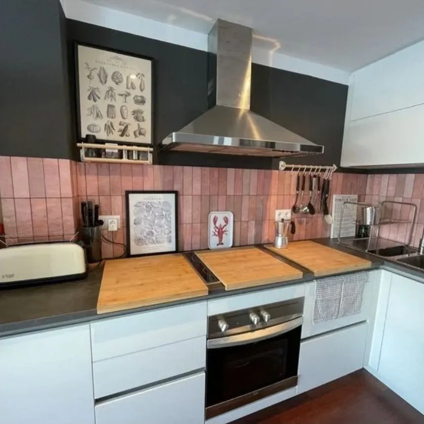 La cocina terminada, con azulejo rosa y encimera de madera