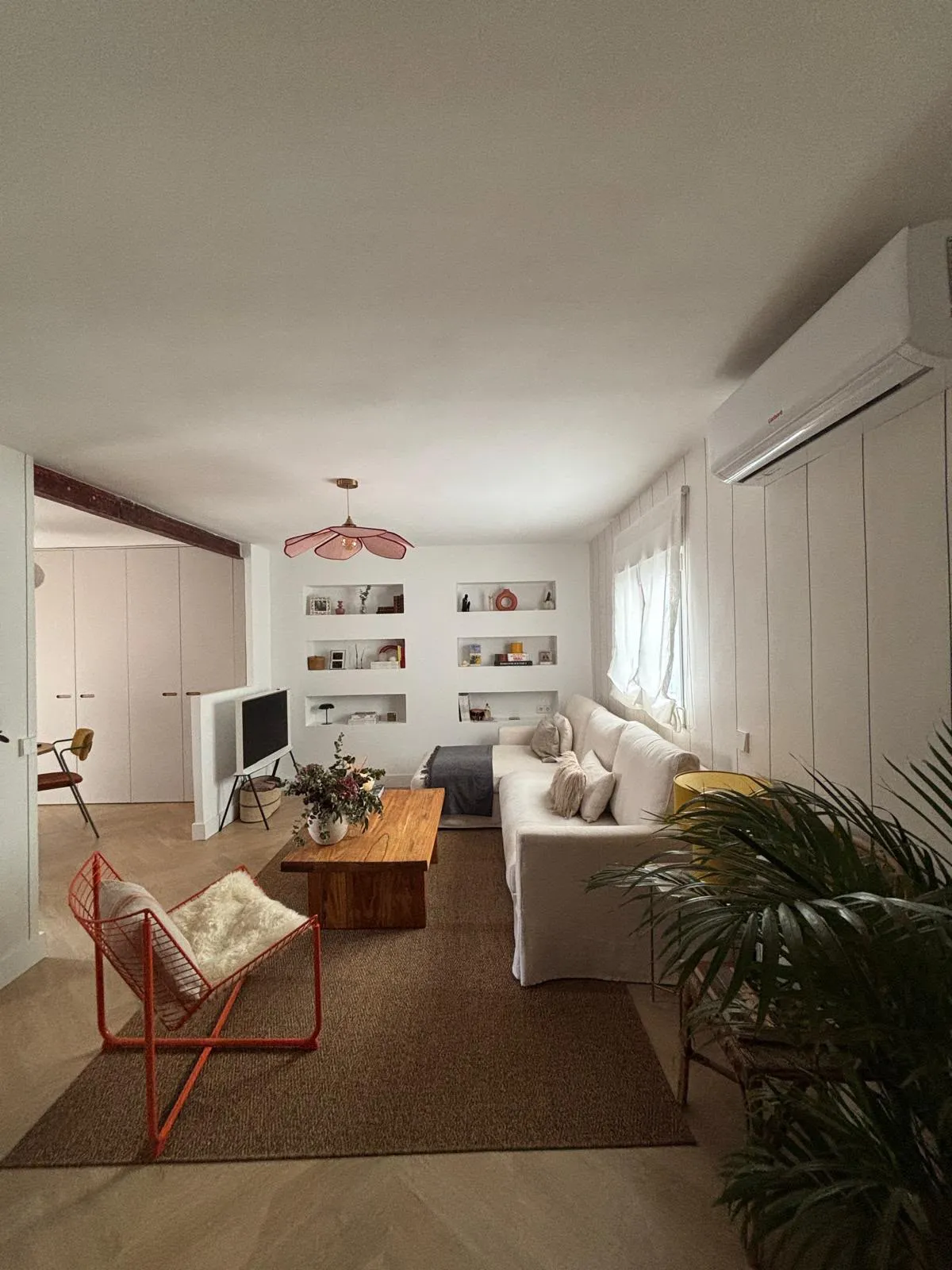 El salón terminado desde el sofá, con las hornacinas vestidas y la lámpara de pétalos