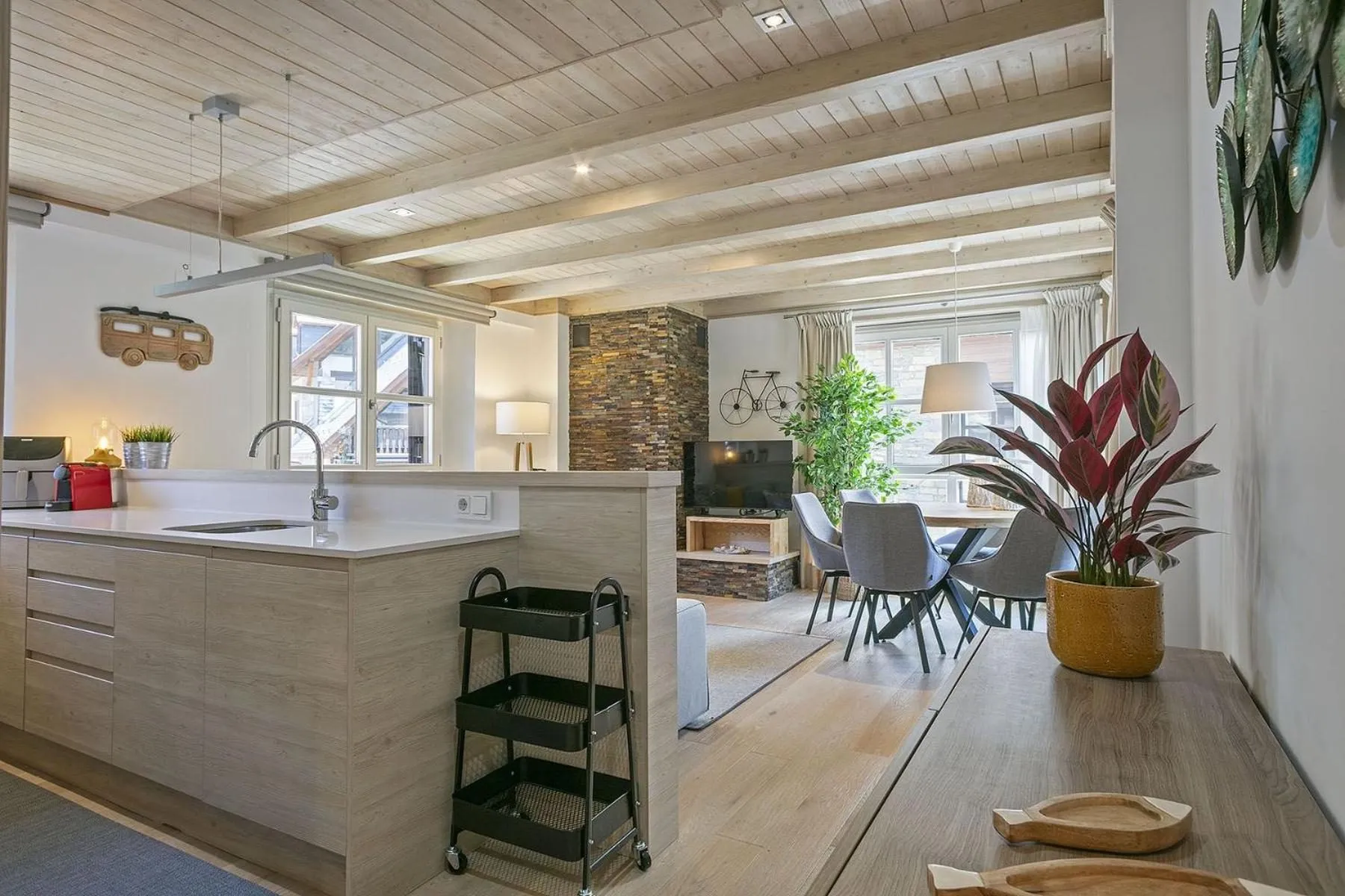 La cocina abierta al salón, con la barra y la chimenea al fondo