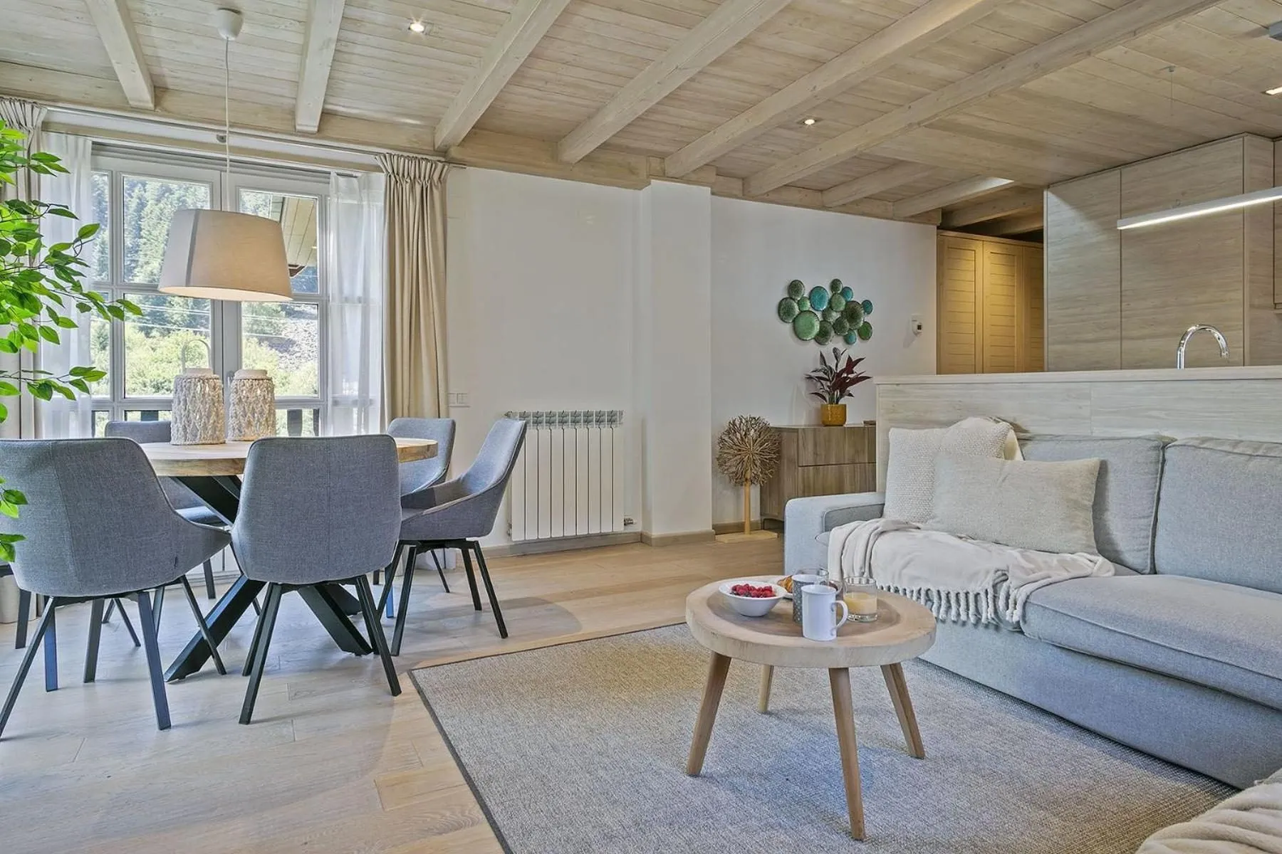El salón comedor, con el sofá rinconero delante y la mesa al fondo
