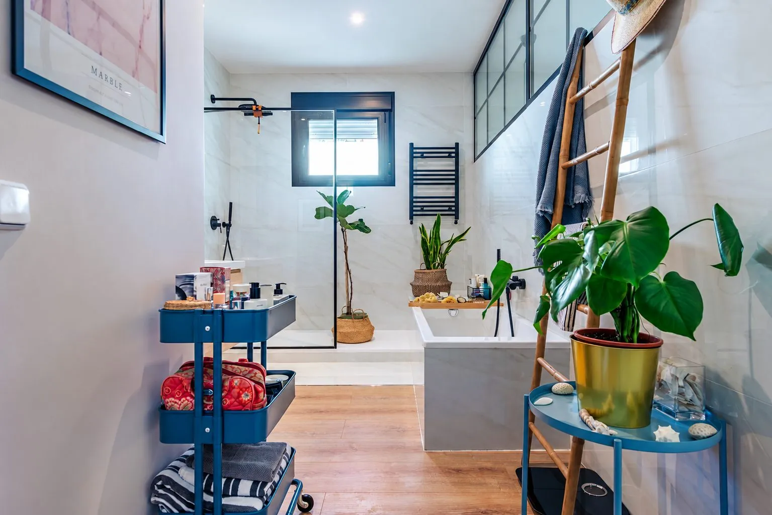 Un baño con ducha de obra, un carrito de ruedas y plantas